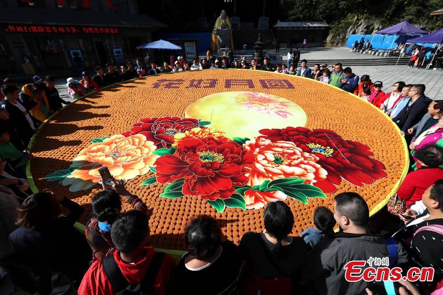 Staff members at Laojun Mountain, a scenic spot in Luoyang City, Central China\'s Henan Province, use 9,999 colorful mooncakes to spell out a beautiful pattern with Chinese characters of Hua Hao Yue Yuan (Blooming flowers and full moon) to celebrate the Mid-Autumn Festival, Sept. 23, 2018. (Photo: China News Service/Wang Zhongju)