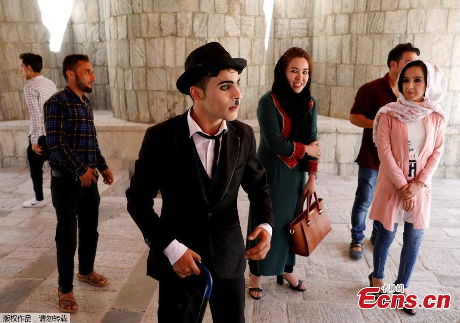 Afghanistan\'s Charlie Chaplin, Karim Asir, 25, talks with his fans before his performance in Kabul, Afghanistan, Aug. 29, 2018. Karim Asir says he has witnessed suicide attacks, explosions and threats from hardline Islamic militant groups, but is determined to waddle and bumble to fulfill the primary goal of his life. (Photo/Agencies)
