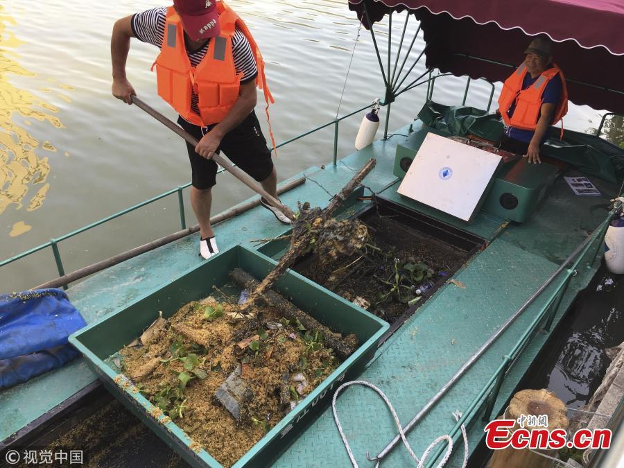 A boat equipped with a new device collects garbage in a river in Pingyang County, East China’s Zhejiang Province, Sept. 25, 2018. The rope-like electronic devices can be remotely controlled to rise above or fall under the water to collect floating garbage. (Photo/VCG)