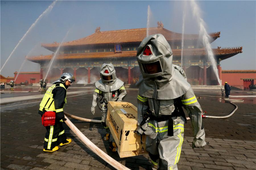 Drills are staged frequently at the Palace Museum in Beijing, where a team is stationed by the east gate to keep watch for fire in turn 24 hours a day. (Photo/CHINA DAILY)
Tests are held every week. Firefighters have to run more than 50 meters within 13 seconds carrying three rolls of 20-meter-long standpipe hoses and connecting them.
Strict practice is essential to remaining vigilant.
Firefighters stationed in residential areas may be called out to fires every day. However, since the Tiananmen Fire Squadron was set up in 1970, there have been no major fires within its 3.74-sq-km jurisdiction, which covers not only the Palace Museum but all of Tiananmen Square.
In 1987, the Palace of Great Brilliance (Jingyanggong) at the museum was hit by lightning and caught fire. The blaze was quickly put out before any damage was caused to cultural relics, although a small part of the roof was charred.
After this, lightning conductors were installed on the roofs of all the buildings at the complex.
Du said: \