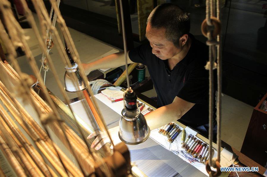 A weaver knits Yun brocade at the Nanjing Yunjin Museum in Nanjing, capital of east China\'s Jiangsu Province, Sept.26, 2018. Yunjin, also called Yun brocade, is traditional Chinese silk brocade made in Nanjing of Jiangsu. Dated from the Eastern Jin Dynasty, it has formed its own characteristics through its development of 1,600 years. Yun brocade is famous for its exquisite craft, elegant patterns and smooth texture, and the making of the artwork requires close cooperation of two weavers, who can produce only five centimeters a day. In 2009, Yun brocade was inscribed on the Representative List of the Intangible Cultural Heritage of Humanity. (Xinhua/Sui Xiankai)