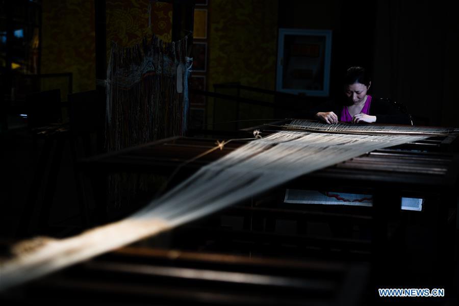 A weaver shows skills of knitting Yun brocade at the Nanjing Yunjin Museum in Nanjing, capital of east China\'s Jiangsu Province, Sept. 26, 2018. Yunjin, also called Yun brocade, is traditional Chinese silk brocade made in Nanjing of Jiangsu. Dated from the Eastern Jin Dynasty, it has formed its own characteristics through its development of 1,600 years. Yun brocade is famous for its exquisite craft, elegant patterns and smooth texture, and the making of the artwork requires close cooperation of two weavers, who can produce only five centimeters a day. In 2009, Yun brocade was inscribed on the Representative List of the Intangible Cultural Heritage of Humanity. (Xinhua/Li Xiang)
