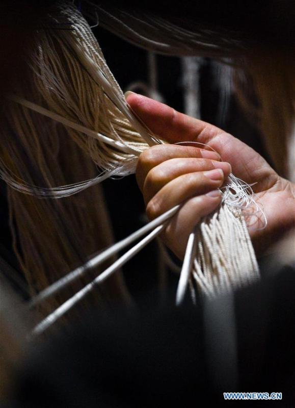 A weaver shows skills of knitting Yun brocade at the Nanjing Yunjin Museum in Nanjing, capital of east China\'s Jiangsu Province, Sept.26, 2018. Yunjin, also called Yun brocade, is traditional Chinese silk brocade made in Nanjing of Jiangsu. Dated from the Eastern Jin Dynasty, it has formed its own characteristics through its development of 1,600 years. Yun brocade is famous for its exquisite craft, elegant patterns and smooth texture, and the making of the artwork requires close cooperation of two weavers, who can produce only five centimeters a day. In 2009, Yun brocade was inscribed on the Representative List of the Intangible Cultural Heritage of Humanity. (Xinhua/Li Xiang)
