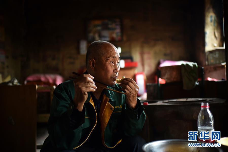 Zhao Naitang, 73, has lunch at the Huangyadong Martyrs Cemetery in Licheng County, North China’s Shanxi Province, Sept. 18, 2018. Huangyadong used to be an arsenal of the Eighth Route Army and a battlefield during the Chinese People\'s War of Resistance against Japanese Aggression. Zhao has been the custodian at the cemetery, where 44 martyrs were buried, since 1991. (Photo/Xinhua)