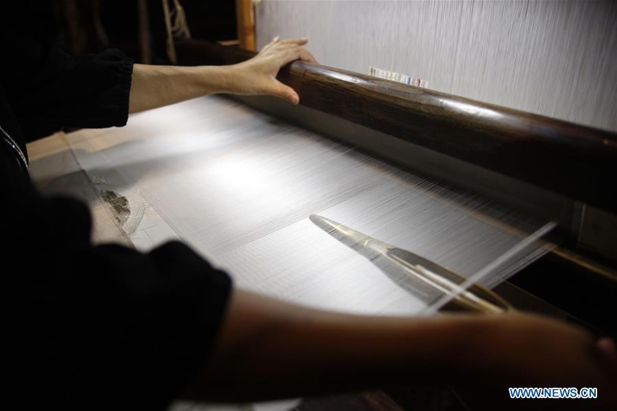 A weaver knits Yun brocade at the Nanjing Yunjin Museum in Nanjing, capital of east China\'s Jiangsu Province, Sept. 26, 2018. Yunjin, also called Yun brocade, is traditional Chinese silk brocade made in Nanjing of Jiangsu. Dated from the Eastern Jin Dynasty, it has formed its own characteristics through its development of 1,600 years. Yun brocade is famous for its exquisite craft, elegant patterns and smooth texture, and the making of the artwork requires close cooperation of two weavers, who can produce only five centimeters a day. In 2009, Yun brocade was inscribed on the Representative List of the Intangible Cultural Heritage of Humanity. (Xinhua/Zhu Weixi)