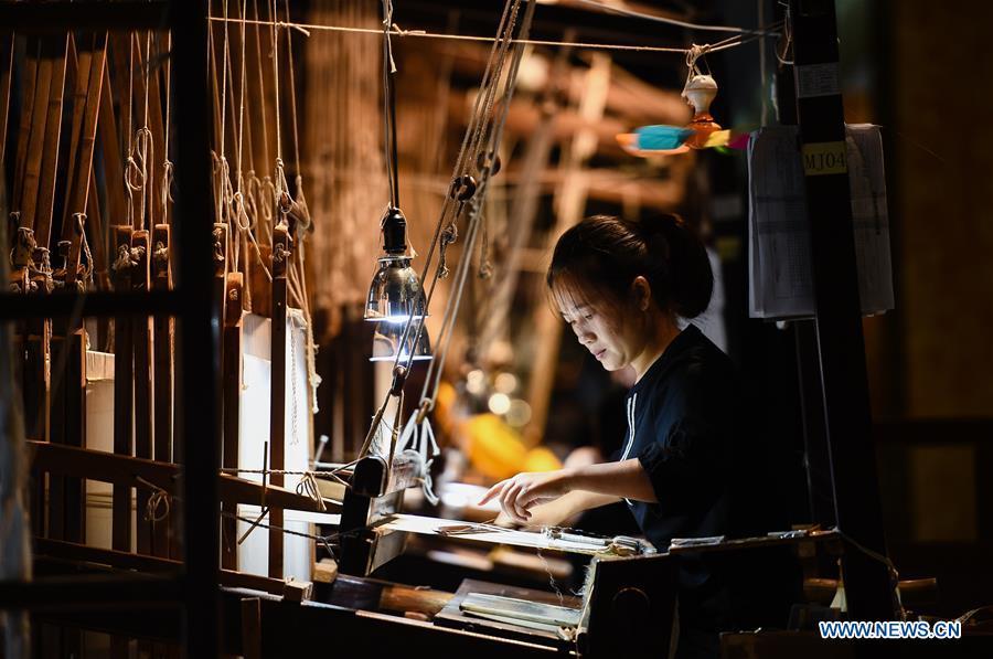 A weaver knits Yun brocade at the Nanjing Yunjin Museum in Nanjing, capital of east China\'s Jiangsu Province, Sept. 26, 2018. Yunjin, also called Yun brocade, is traditional Chinese silk brocade made in Nanjing of Jiangsu. Dated from the Eastern Jin Dynasty, it has formed its own characteristics through its development of 1,600 years. Yun brocade is famous for its exquisite craft, elegant patterns and smooth texture, and the making of the artwork requires close cooperation of two weavers, who can produce only five centimeters a day. In 2009, Yun brocade was inscribed on the Representative List of the Intangible Cultural Heritage of Humanity. (Xinhua/Li Xiang)