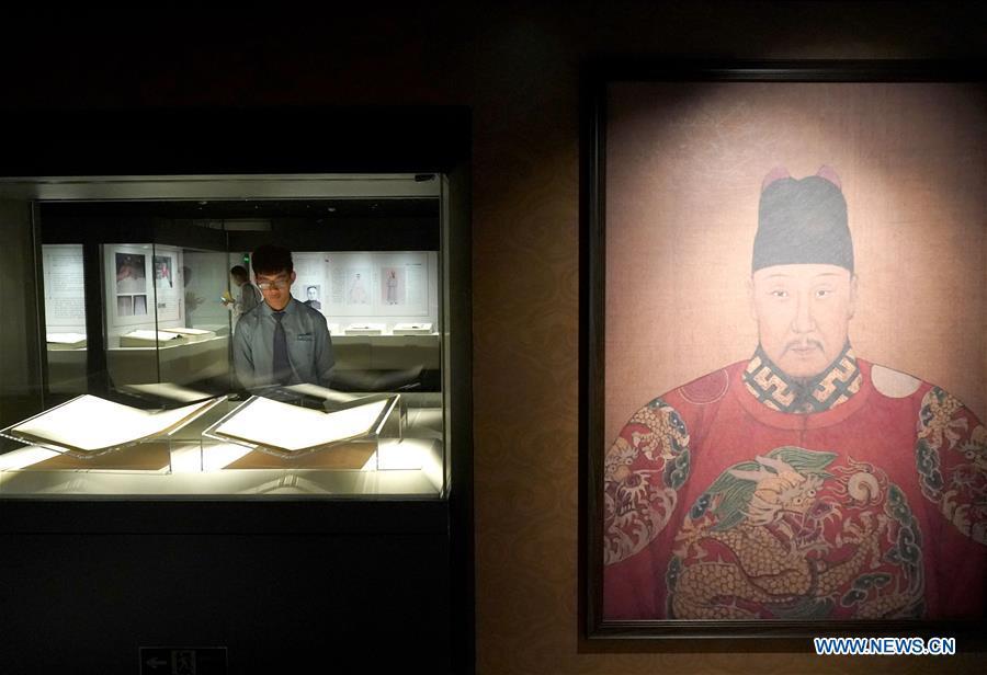 A staff member views exhibits during an exhibition on Yongle Encyclopaedia at National Library of China in Beijing, capital of China, Sept. 28, 2018. Yongle Encyclopaedia is China\'s first encyclopaedia compiled in the Ming Dynasty (1368-1644). The exhibition kicked off here on Friday. (Xinhua/Yin Gang)