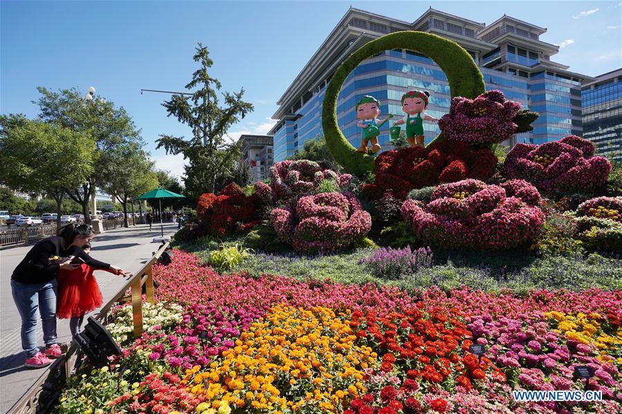 Pedestrians view flower parterres in Beijing, capital of China, Sept. 29, 2018. Beijing is decorated with ornamental flower parterres for the upcoming China\'s National Day. (Xinhua/Ju Huanzong)