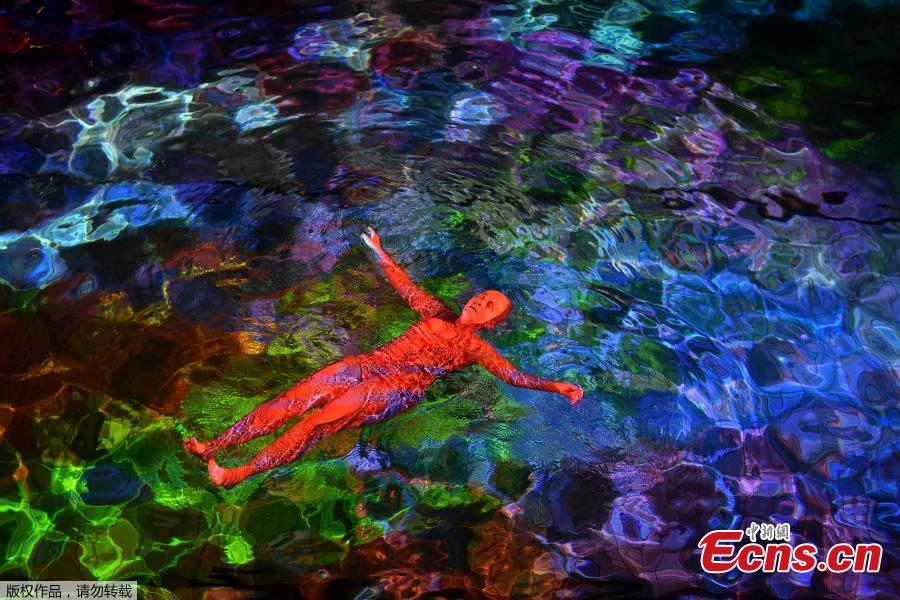 A woman swims in the lighted water of the Hirschengraben indoor swimming pool in Bern during an artistic performance by Swiss visual artist Pipilotti Rist and World Wide Fund for Nature (WWF) Switzerland non-governmental organization to denounce the disappearance of corals due to the warming and the acidification of the ocean on October 7, 2018. (Photo/Agencies)