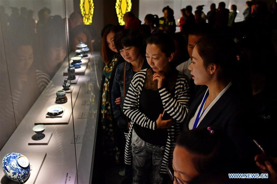 People listen to introduction of relics by a guide at an exhibition in Taiyuan Museum, north China\'s Shanxi Province, Oct. 7, 2018. An exhibition of cultural relics from the Palace Museum attracted local residents. (Xinhua/Cao Yang)