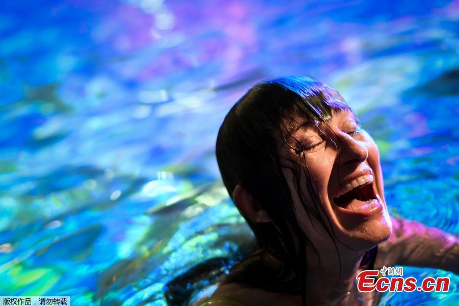 Swiss visual artist Pipilotti Rist laughs as she poses in the lighted water of the Hirschengraben indoor swimming pool during an artistic performance and World Wide Fund for Nature (WWF) Switzerland non-governmental organization to denounce the disappearance of corals due to the warming and the acidification of the ocean on October 7, 2018. (Photo/Agencies)
