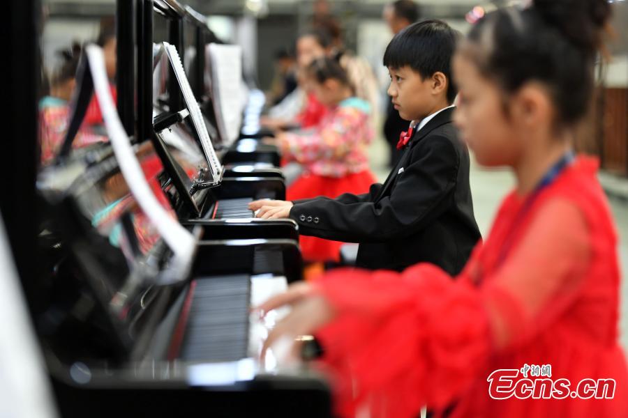 Participants play pianos at the same time in an attempt to set a Guinness World Record for the most pianos played simultaneously at the R?NISCH industry park in Wuqiang County, North China’s Hebei Province, Oct. 6, 2018. A total of 666 pianos were played in the challenge. (Photo: China News Service/Zhai Yujia)