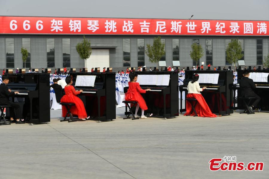 Participants play pianos at the same time in an attempt to set a Guinness World Record for the most pianos played simultaneously at the R?NISCH industry park in Wuqiang County, North China’s Hebei Province, Oct. 6, 2018. A total of 666 pianos were played in the challenge. (Photo: China News Service/Zhai Yujia)