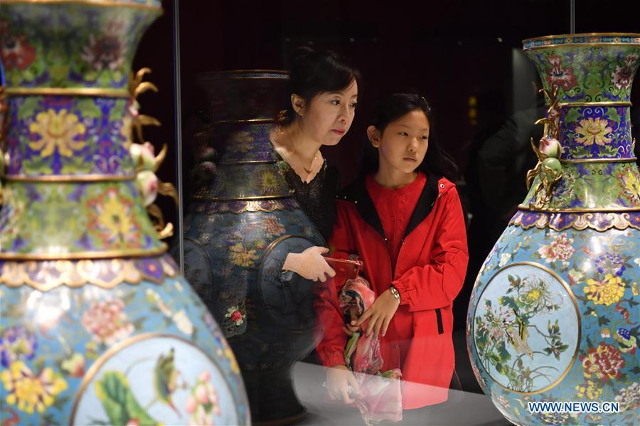 People look at cultural relics displayed at an exhibition in Taiyuan Museum, north China\'s Shanxi Province, Oct. 7, 2018. An exhibition of cultural relics from the Palace Museum attracted local residents. (Xinhua/Cao Yang)