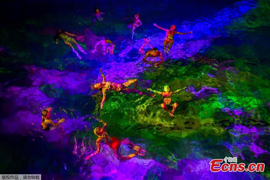 People swim in the lighted water of the Hirschengraben indoor swimming pool in Bern during an artistic performance by Swiss visual artist Pipilotti Rist and World Wide Fund for Nature (WWF) Switzerland non-governmental organization to denounce the disappearance of corals due to the warming and the acidification of the ocean on October 7, 2018. (Photo/Agencies)