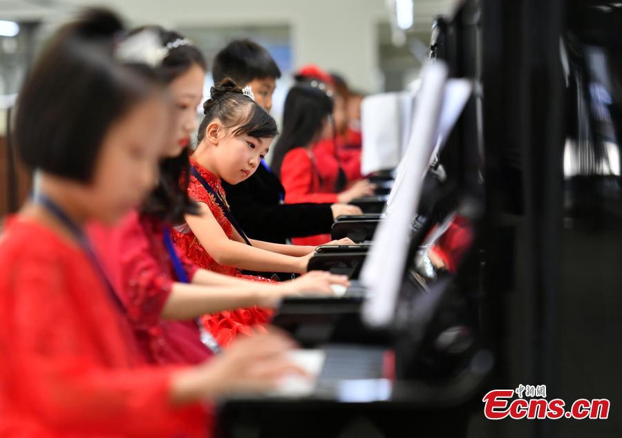 Participants play pianos at the same time in an attempt to set a Guinness World Record for the most pianos played simultaneously at the R?NISCH industry park in Wuqiang County, North China’s Hebei Province, Oct. 6, 2018. A total of 666 pianos were played in the challenge. (Photo: China News Service/Zhai Yujia)