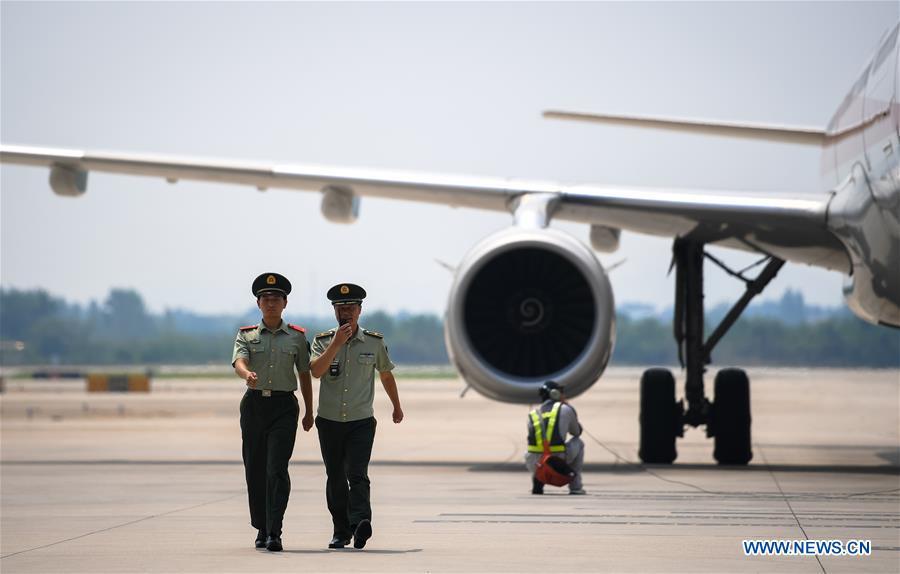 Wang Zhiguo (R) patrols a parking apron of Nanjing Lukou International Airport in Nanjing, capital of east China\'s Jiangsu Province, Aug. 7, 2018. Wang Jicai, who used to be head of the militia post on Kaishan Island in Jiangsu Province, started working on the island in the Yellow Sea with his wife in 1986. He died of sudden illness while on duty in July of 2018 at the age of 58. Wang Zhiguo, son of Wang Jicai, became a frontier defence policeman after his graduation from Nanjing University of Aeronautics and Astronautics in 2013. He had been assigned to many security tasks for major events during 5 years\' working. (Xinhua/Li Xiang)