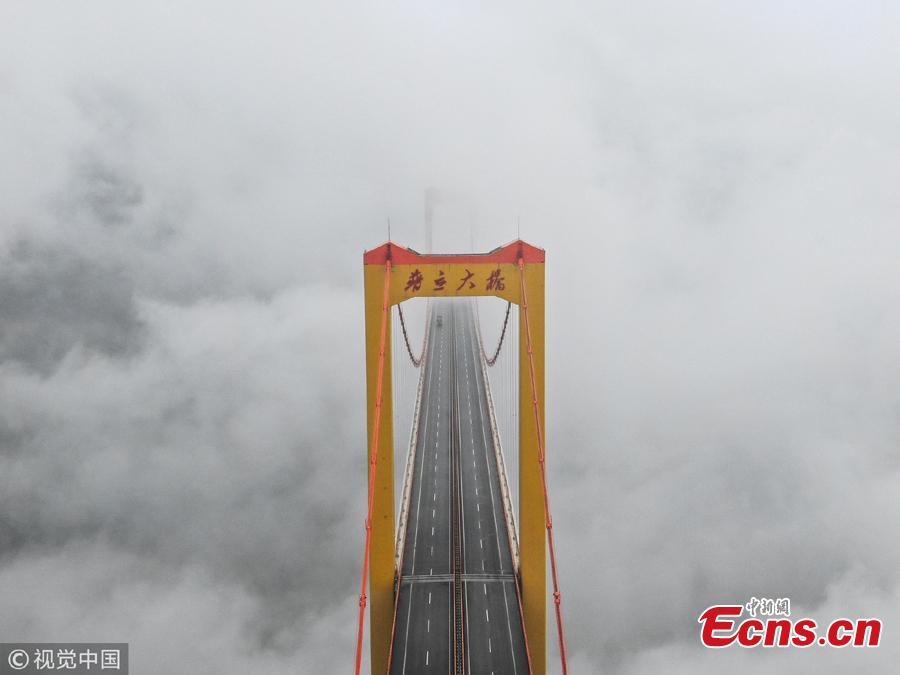 Clouds surround the Puli Bridge, which connects Guizhou and Yunnan provinces in southwest China. The bridge, one of the world\'s highest, stands hundreds of meters above the Beipan River and links Duge of Guizhou and Puli of Yunnna, attracting tourists with its stunning views. (Photo/VCG)