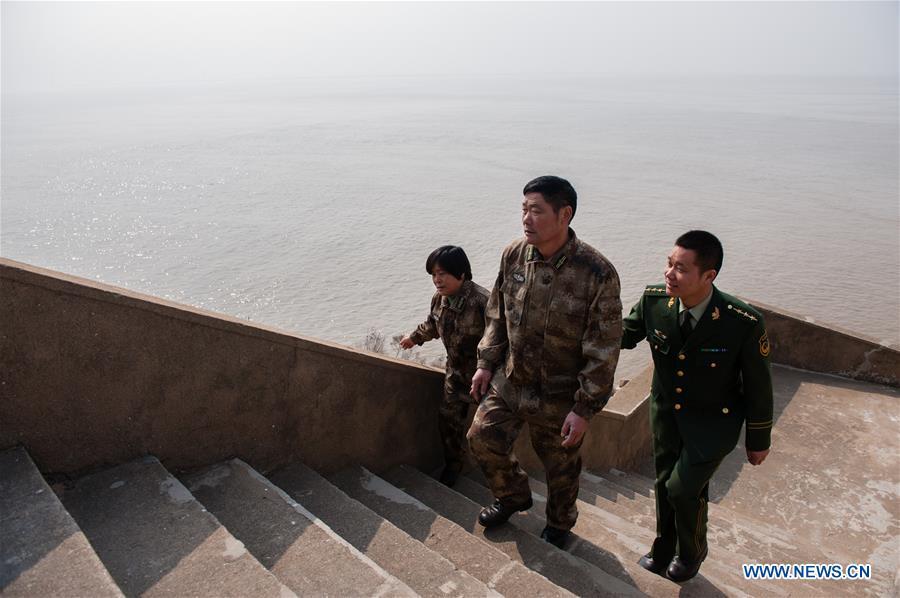 Wang Zhiguo (R) walks with his parents on Kaishan Island of Guanyun County, east China\'s Jiangsu Province, Feb. 13, 2015. Wang Jicai, who used to be head of the militia post on Kaishan Island in Jiangsu Province, started working on the island in the Yellow Sea with his wife in 1986. He died of sudden illness while on duty in July of 2018 at the age of 58. Wang Zhiguo, son of Wang Jicai, became a frontier defence policeman after his graduation from Nanjing University of Aeronautics and Astronautics in 2013. He had been assigned to many security tasks for major events during 5 years\' working. (Xinhua/Li Xiang)