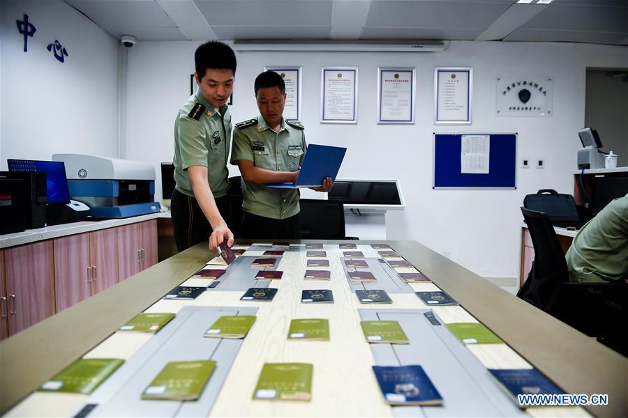 Wang Zhiguo (R) works at an inspection station of Nanjing Lukou International Airport in Nanjing, capital of east China\'s Jiangsu Province, Aug. 7, 2018. Wang Jicai, who used to be head of the militia post on Kaishan Island in Jiangsu Province, started working on the island in the Yellow Sea with his wife in 1986. He died of sudden illness while on duty in July of 2018 at the age of 58. Wang Zhiguo, son of Wang Jicai, became a frontier defence policeman after his graduation from Nanjing University of Aeronautics and Astronautics in 2013. He had been assigned to many security tasks for major events during 5 years\' working. (Xinhua/Li Xiang)