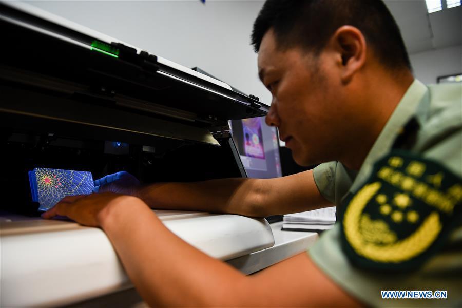 Wang Zhiguo works at an inspection station of Nanjing Lukou International Airport in Nanjing, capital of east China\'s Jiangsu Province, Aug. 7, 2018. Wang Jicai, who used to be head of the militia post on Kaishan Island in Jiangsu Province, started working on the island in the Yellow Sea with his wife in 1986. He died of sudden illness while on duty in July of 2018 at the age of 58. Wang Zhiguo, son of Wang Jicai, became a frontier defence policeman after his graduation from Nanjing University of Aeronautics and Astronautics in 2013. He had been assigned to many security tasks for major events during 5 years\' working. (Xinhua/Li Xiang)