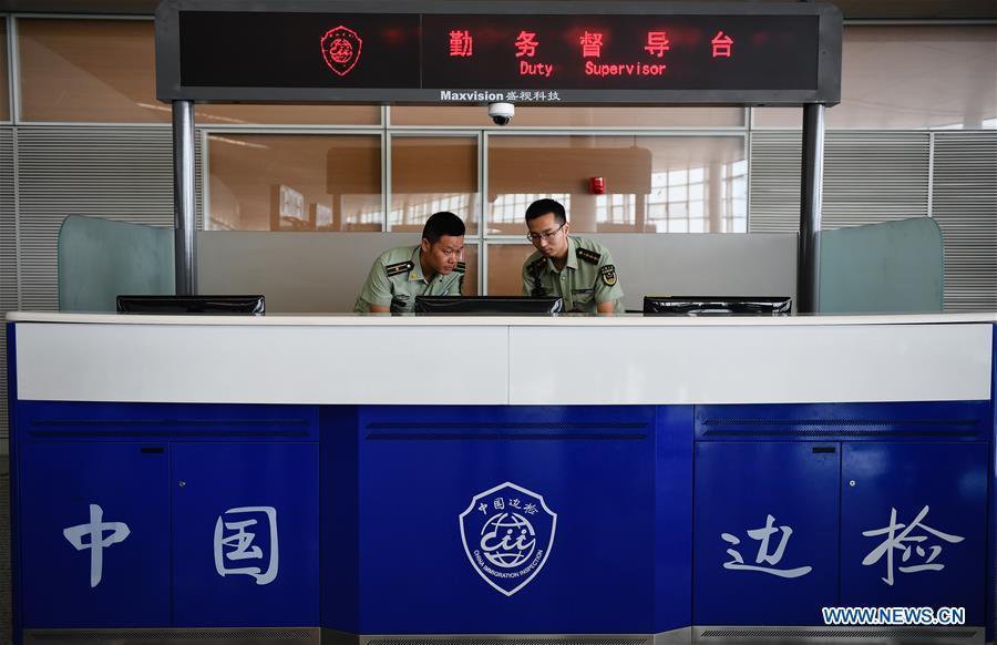 Wang Zhiguo (L) does data analysis with colleagues at Nanjing Lukou International Airport in Nanjing, capital of east China\'s Jiangsu Province, Aug. 7, 2018. Wang Jicai, who used to be head of the militia post on Kaishan Island in Jiangsu Province, started working on the island in the Yellow Sea with his wife in 1986. He died of sudden illness while on duty in July of 2018 at the age of 58. Wang Zhiguo, son of Wang Jicai, became a frontier defence policeman after his graduation from Nanjing University of Aeronautics and Astronautics in 2013. He had been assigned to many security tasks for major events during 5 years\' working. (Xinhua/Li Xiang)