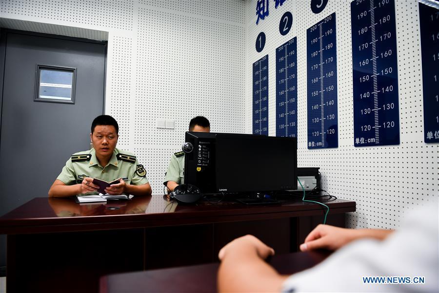 Wang Zhiguo (L) questions a suspect at an inspection station of Nanjing Lukou International Airport in Nanjing, capital of east China\'s Jiangsu Province, Aug. 7, 2018. Wang Jicai, who used to be head of the militia post on Kaishan Island in Jiangsu Province, started working on the island in the Yellow Sea with his wife in 1986. He died of sudden illness while on duty in July of 2018 at the age of 58. Wang Zhiguo, son of Wang Jicai, became a frontier defence policeman after his graduation from Nanjing University of Aeronautics and Astronautics in 2013. He had been assigned to many security tasks for major events during 5 years\' working. (Xinhua/Li Xiang)