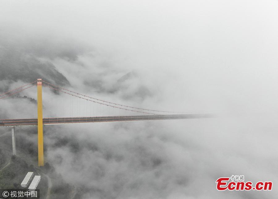 Clouds surround the Puli Bridge, which connects Guizhou and Yunnan provinces in southwest China. The bridge, one of the world\'s highest, stands hundreds of meters above the Beipan River and links Duge of Guizhou and Puli of Yunnna, attracting tourists with its stunning views. (Photo/VCG)