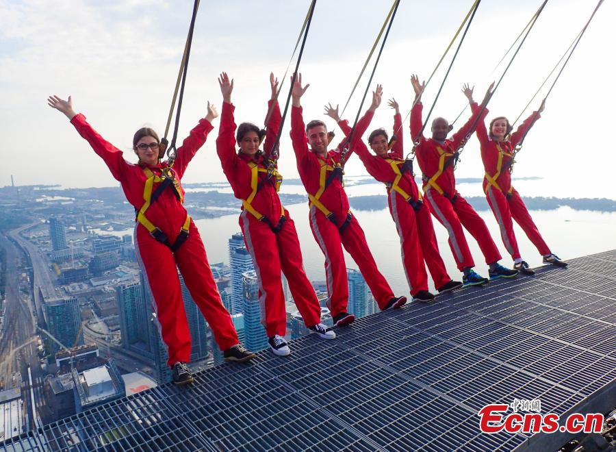 Six new Canadians take their oath of citizenship while harnessed on the CN Tower\'s \