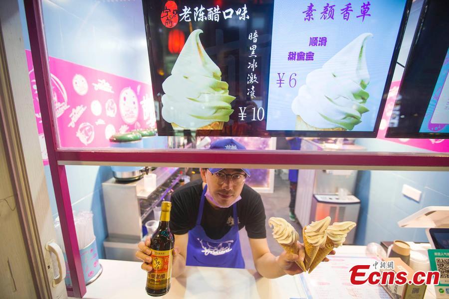 A man shows ice cream flavored with mature vinegar in Taiyuan, capital of north China\'s Shanxi Province, October 9, 2018. (Photo: China News Service/ Zhang Yun)