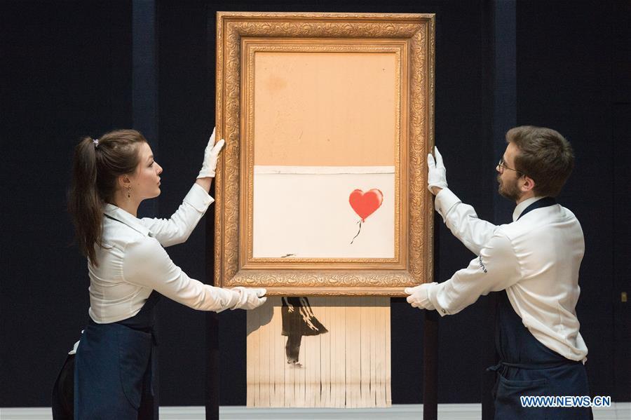 Sotheby\'s staff members present Banksy\'s \