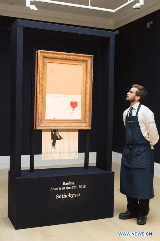 A staff member of Sotheby\'s presents Banksy\'s \