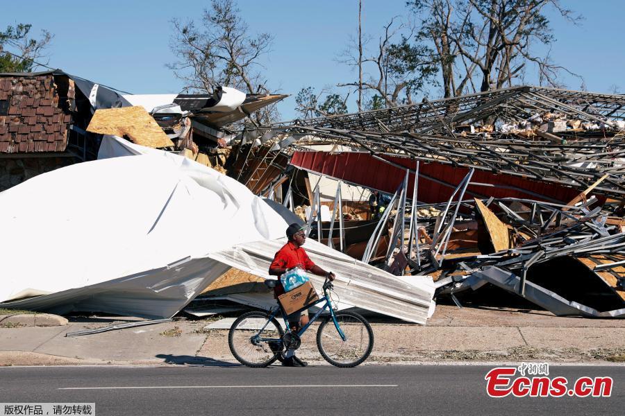 A man carries food and water past a building damaged by Hurricane Michael in Parker, Florida, U.S., October 13, 2018. Dozens of people remained missing on Sunday in Florida Panhandle communities reduced to ruins by Hurricane Michael as rescuers said they expected the death toll to rise and survivors grappled with power outages and shortages of food and water. (Photo/Agencies)