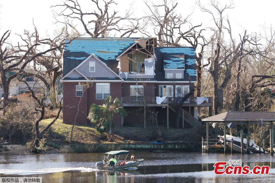 A person sails a boat past a house damaged by Hurricane Michael in Panama City, Florida, U.S., October 13, 2018. Dozens of people remained missing on Sunday in Florida Panhandle communities reduced to ruins by Hurricane Michael as rescuers said they expected the death toll to rise and survivors grappled with power outages and shortages of food and water. (Photo/Agencies)