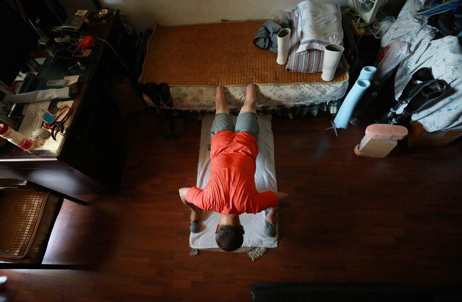 Xia practices push-ups at home. (Photo/China Daily)
\