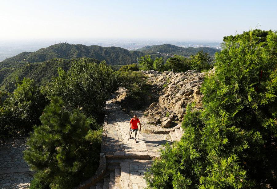 Xia Boyu climbs the incense burner peak in the Beijing Xiangshan Park.(Photo/China Daily)
Xia Boyu, who climbed Qomolangma on his fifth attempt to become China\'s first leg amputee to conquer the world\'s highest mountain at 8,844 meters, refuses to give up.
Since he conquered the summit of Qomolangma recently, the 69-year-old leg amputee, Xia Boyu, has become an inspirational figure for the Chinese public with his story of never giving up.