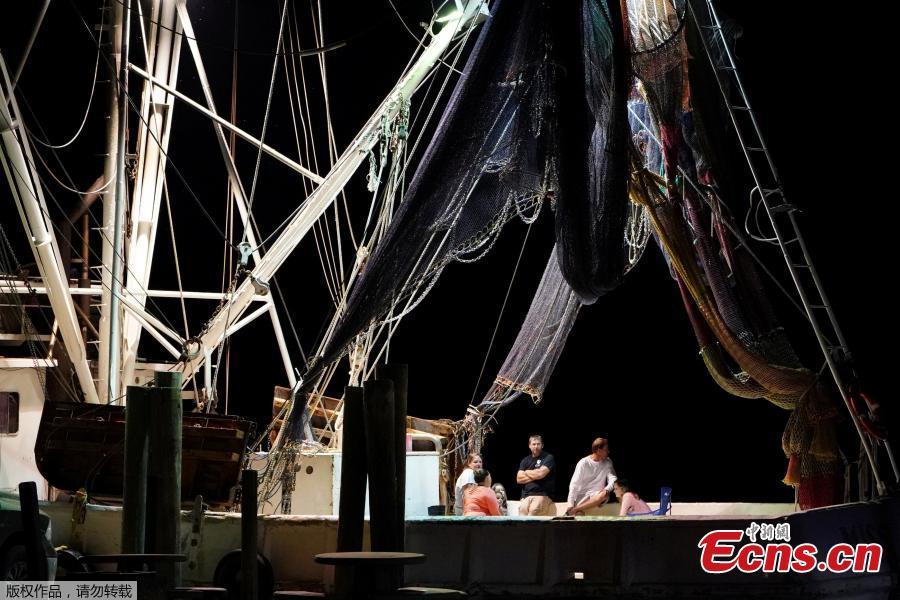 Fishermen sit on the back deck of their boat with the lights on following Hurricane Michael in Apalachicola, Florida, U.S., October 13, 2018. Dozens of people remained missing on Sunday in Florida Panhandle communities reduced to ruins by Hurricane Michael as rescuers said they expected the death toll to rise and survivors grappled with power outages and shortages of food and water. (Photo/Agencies)