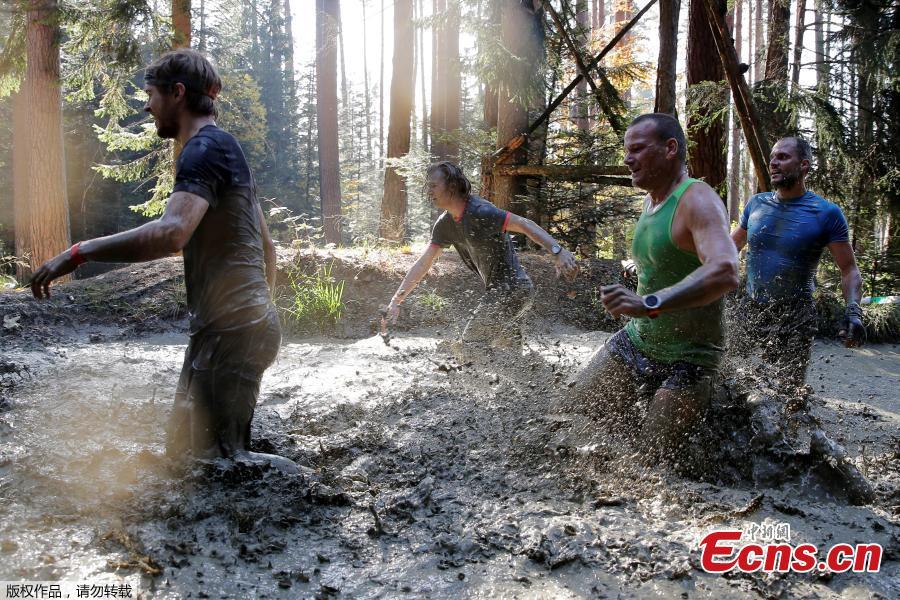 Participants compete during the \'Wild Boar Dirt Run\' (Wildsau Dirt Run) near Brand-Laaben, Austria, October 13, 2018. People took part in a hard obstacle course in three distances 5, 10 and 20 kilometers. (Photo/Agencies)