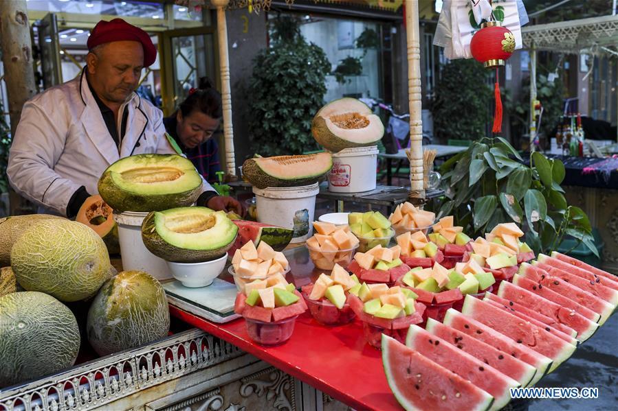 A vendor sells fruits at a night market in Kashgar City, northwest China\'s Xinjiang Uygur Autonomous Region, Oct. 16, 2018. The ancient oasis city of Kashgar, in the westernmost part of China near the border with Kyrgyzstan, Tajikistan, Afghanistan, and Pakistan, was an important staging post on the original Silk Road and has been revitalized as a bustling hub of business and different cultures. (Xinhua/Hu Huhu)
