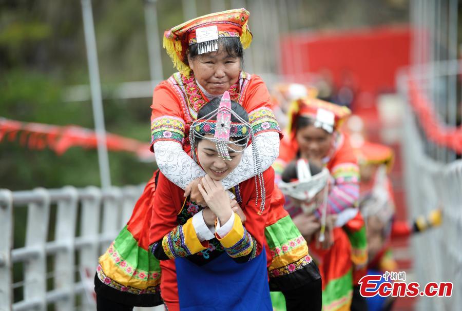 Women carrying their mothers-in-law on their back compete in a race on the 140-meter-long glass bridge in Jiulong River National Forest Park in Hunan Province, Oct. 16, 2018, ahead of the Double Nine Festival. Women from the She and Yao ethnic groups participated the competition. The 9th day of the 9th lunar month is the traditional Chongyang Festival, or Double Nine Festival, which falls on Oct. 17 this year. (Photo: China News Service/Yang Huafeng)