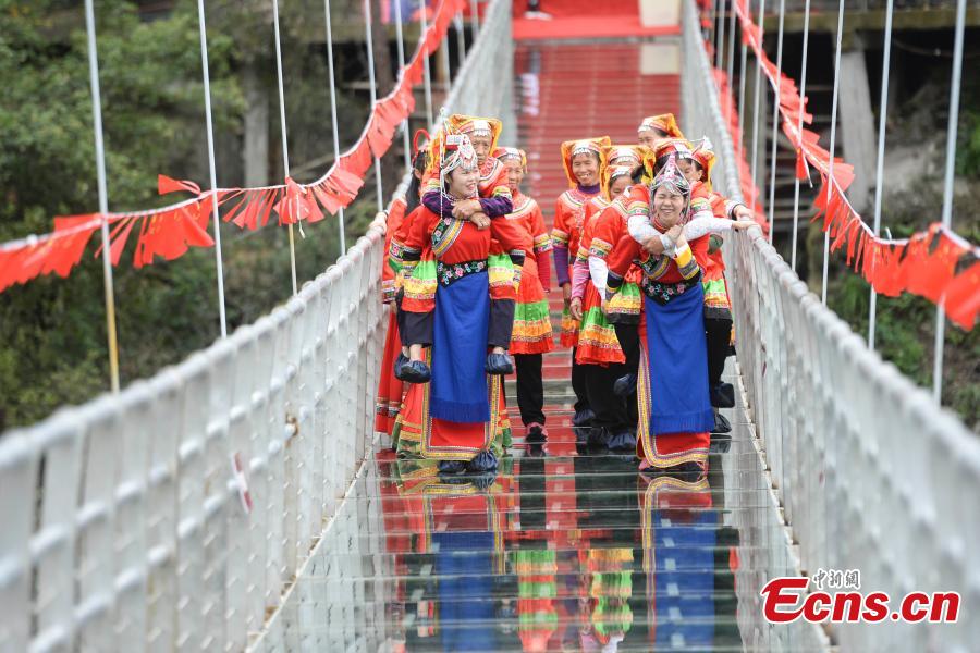 Women carrying their mothers-in-law on their back compete in a race on the 140-meter-long glass bridge in Jiulong River National Forest Park in Hunan Province, Oct. 16, 2018, ahead of the Double Nine Festival. Women from the She and Yao ethnic groups participated the competition. The 9th day of the 9th lunar month is the traditional Chongyang Festival, or Double Nine Festival, which falls on Oct. 17 this year. (Photo: China News Service/Yang Huafeng)