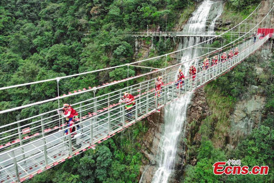 Women carrying their mothers-in-law on their back compete in a race on the 140-meter-long glass bridge in Jiulong River National Forest Park in Hunan Province, Oct. 16, 2018, ahead of the Double Nine Festival. Women from the She and Yao ethnic groups participated the competition. The 9th day of the 9th lunar month is the traditional Chongyang Festival, or Double Nine Festival, which falls on Oct. 17 this year. (Photo: China News Service/Yang Huafeng)