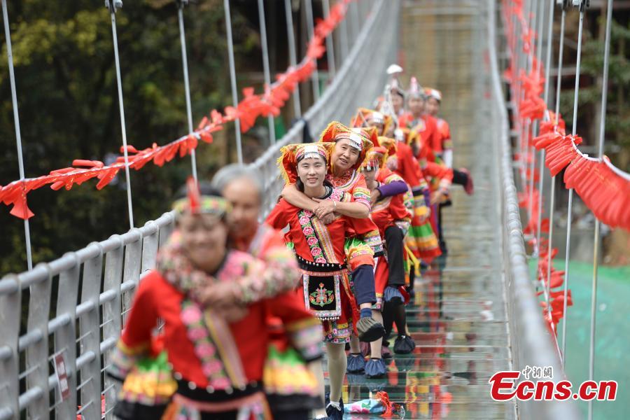 Women carrying their mothers-in-law on their back compete in a race on the 140-meter-long glass bridge in Jiulong River National Forest Park in Hunan Province, Oct. 16, 2018, ahead of the Double Nine Festival. Women from the She and Yao ethnic groups participated the competition. The 9th day of the 9th lunar month is the traditional Chongyang Festival, or Double Nine Festival, which falls on Oct. 17 this year. (Photo: China News Service/Yang Huafeng)