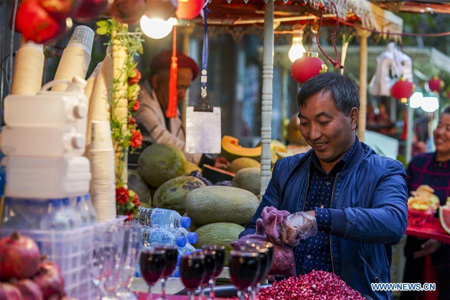 A fruit vendor juices pomegranates at a night market in Kashgar City, northwest China\'s Xinjiang Uygur Autonomous Region, Oct. 16, 2018. The ancient oasis city of Kashgar, in the westernmost part of China near the border with Kyrgyzstan, Tajikistan, Afghanistan, and Pakistan, was an important staging post on the original Silk Road and has been revitalized as a bustling hub of business and different cultures. (Xinhua/Hu Huhu)