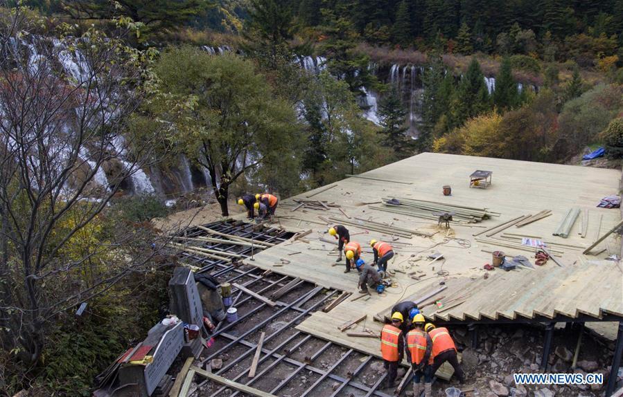 In this aerial photo taken on Oct. 18, 2018, workers repair a lookout platform at the Jiuzhaigou Valley Scenic Area in Jiuzhaigou County, southwest China\'s Sichuan Province. The magnitude-7.0 earthquake that hit here on Aug. 8, 2017 and the flooding of this summer caused damages of various degrees to the Jiuzhaigou Valley Scenic Area, which has been temporarily closed since July for renovation. (Xinhua/Deng Jian)