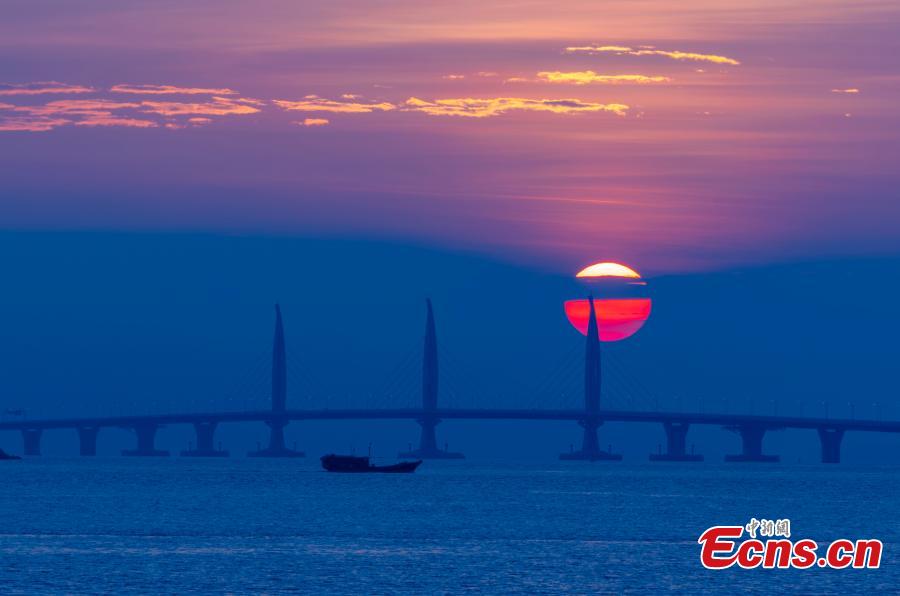 A view of the Hong Kong-Zhuhai-Macao Bridge at sunrise from Qinglv Road in Zhuhai City, South China’s Guangdong Province, Oct. 22, 2018. The world\'s longest sea bridge will start operation on Oct. 24, further integrating cities in the Pearl River Delta. (Photo: China News Service/Zhang Wei)