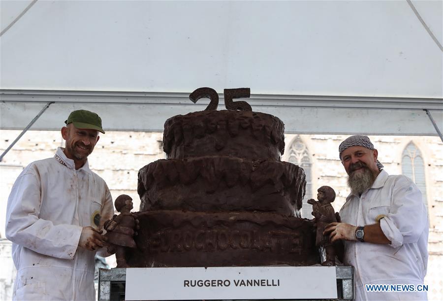Artists pose for photos with the chocolate sculpture they created during the 25th international chocolate festival \