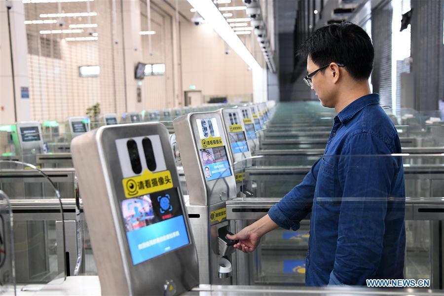 A staff worker demonstrates passing through the automatic channel in Zhuhai Port of Hong Kong-Zhuhai-Macao Bridge in Zhuhai, south China\'s Guangdong Province, Oct. 18, 2018. Customs clearance between Macao and Zhuhai will be carried out on a \