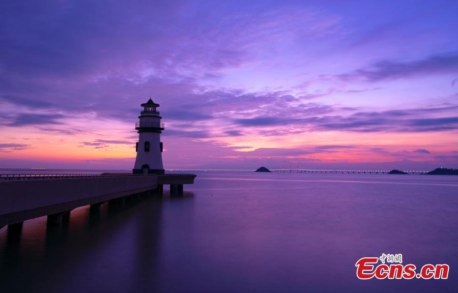 A view of the Hong Kong-Zhuhai-Macao Bridge at sunrise from Qinglv Road in Zhuhai City, South China’s Guangdong Province, Oct. 22, 2018. The world\'s longest sea bridge will start operation on Oct. 24, further integrating cities in the Pearl River Delta. (Photo: China News Service/Zhang Wei)