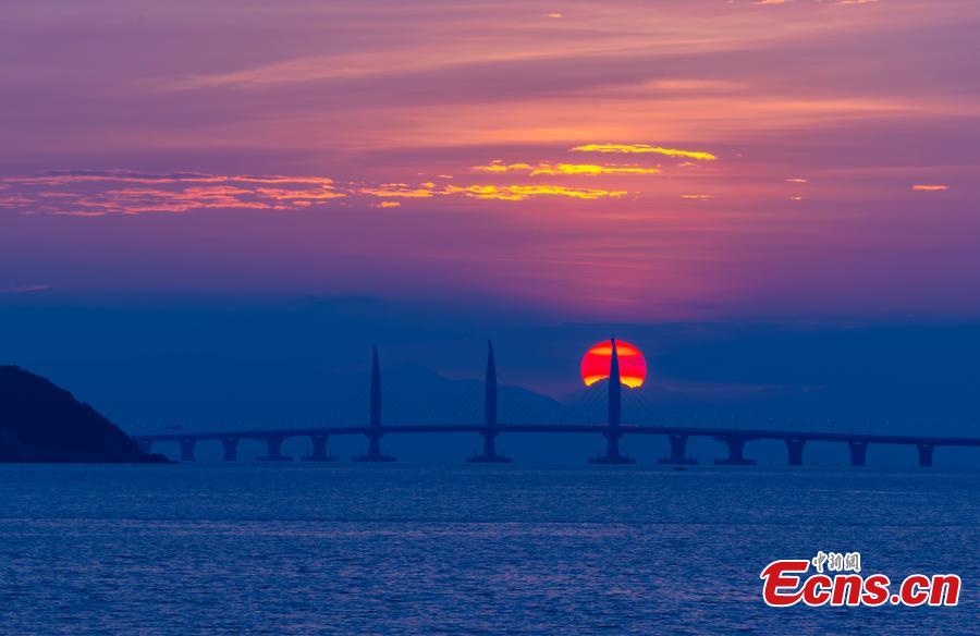 A view of the Hong Kong-Zhuhai-Macao Bridge at sunrise from Qinglv Road in Zhuhai City, South China’s Guangdong Province, Oct. 22, 2018. The world\'s longest sea bridge will start operation on Oct. 24, further integrating cities in the Pearl River Delta. (Photo: China News Service/Zhang Wei)